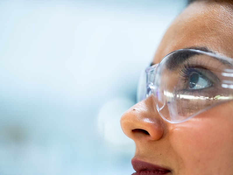 Scientist with safety goggles in tissue culture laboratory